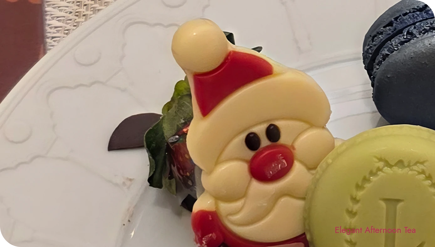Chocolate-dipped strawberries topped with a Santa decoration on the holiday sweets plate