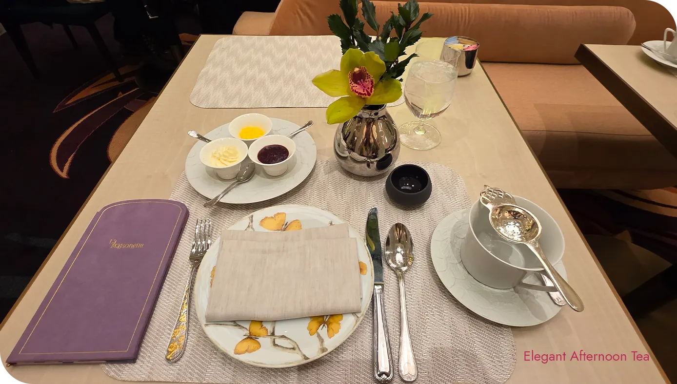 Table setting at La Maisonette with menu, orchid bud vase, and place setting for afternoon tea