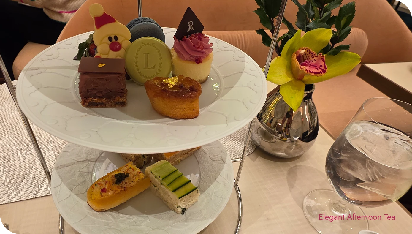 Tiered afternoon tea stand with holiday desserts on the top tier and tea sandwiches on the lower tier at the St. Regis New York