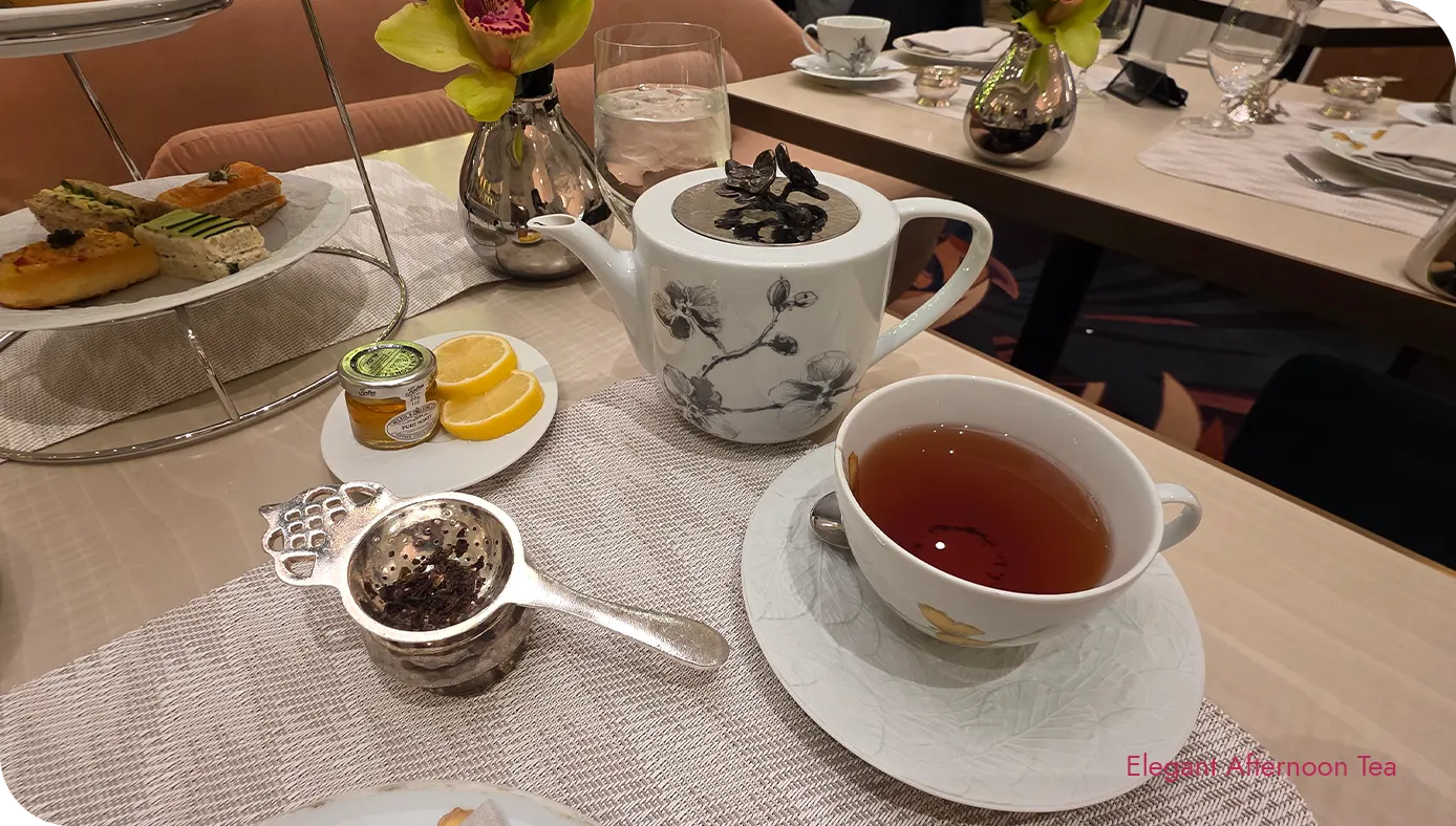 Teapot and teacup with silver tea strainer on the table during afternoon tea service at The St. Regis New York