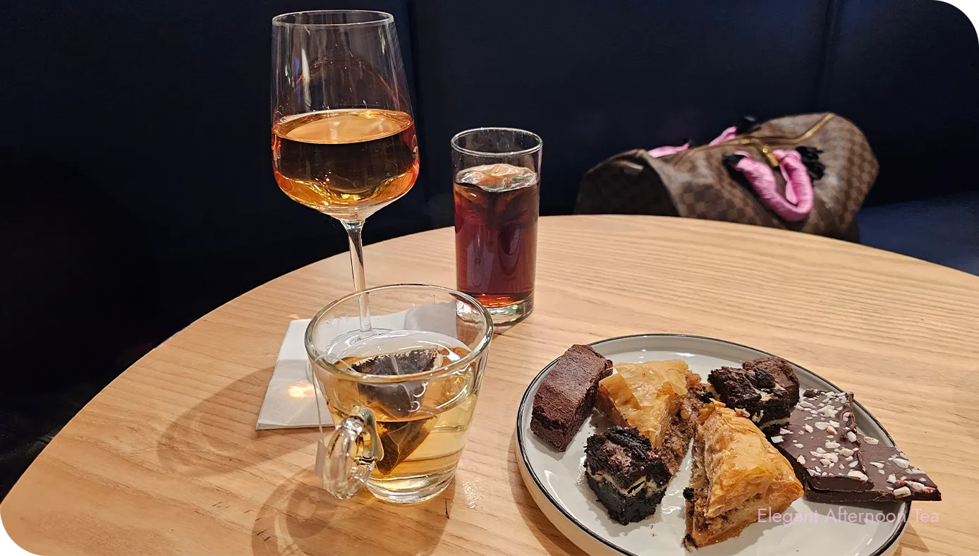 Drinks and desserts arranged on a lounge table with a banquette in the background
